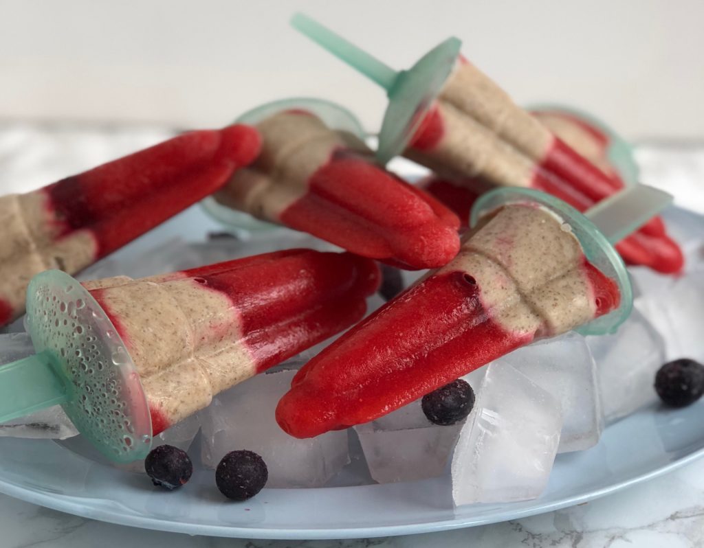 Several popsicles lying on a plate with ice